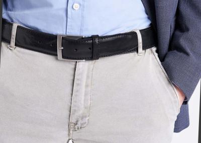 juodas klasikinis vyriskas odinis dirzas i kostiuines kelnes prie svarko ofise vestuvems brangus kokybiskas