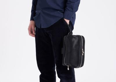 vyras laiko odine kosmetine patogi juoda kelioniu odine kosmetine dovana